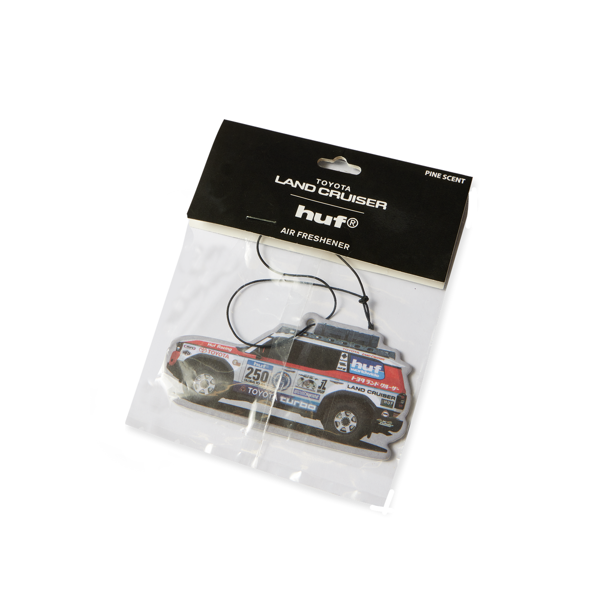 Désodorisant HUF x Toyota Land Cruiser multicolore en forme de véhicule de rallye — dans son emballage.